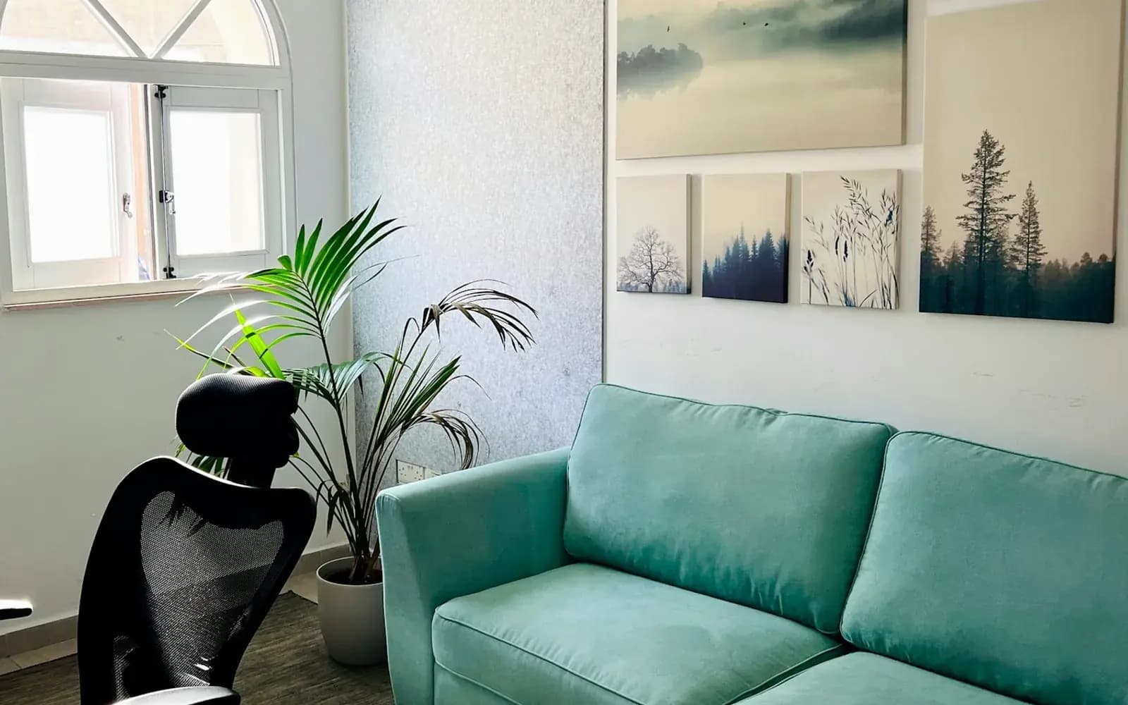 Sitzecke mit Sofa und einer Wand aus gerahmten Drucken