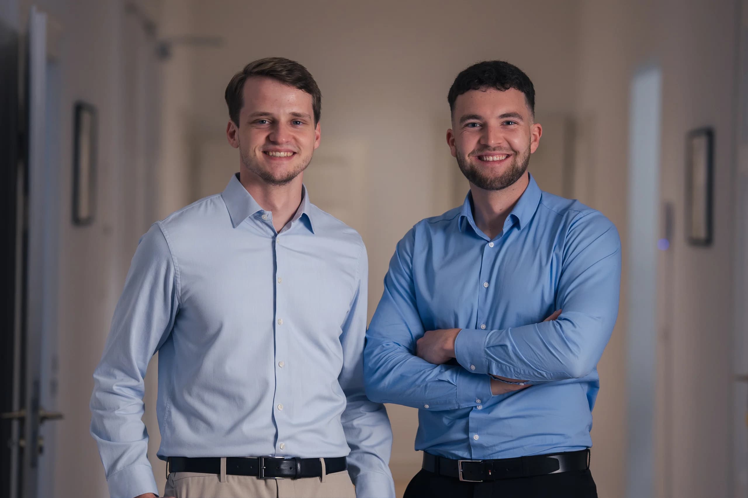 Zwei Kollegen aus dem BLAID-Team nebeneinander im Büroflur